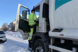 Jäteautonkuljettajaa kipeää lumikasasta jäteauton ohjaamoon.