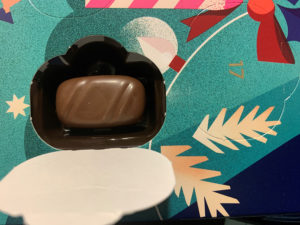 Lähikuva suklaakalenterin luukusta, jossa makeinen vielä paikallaan.