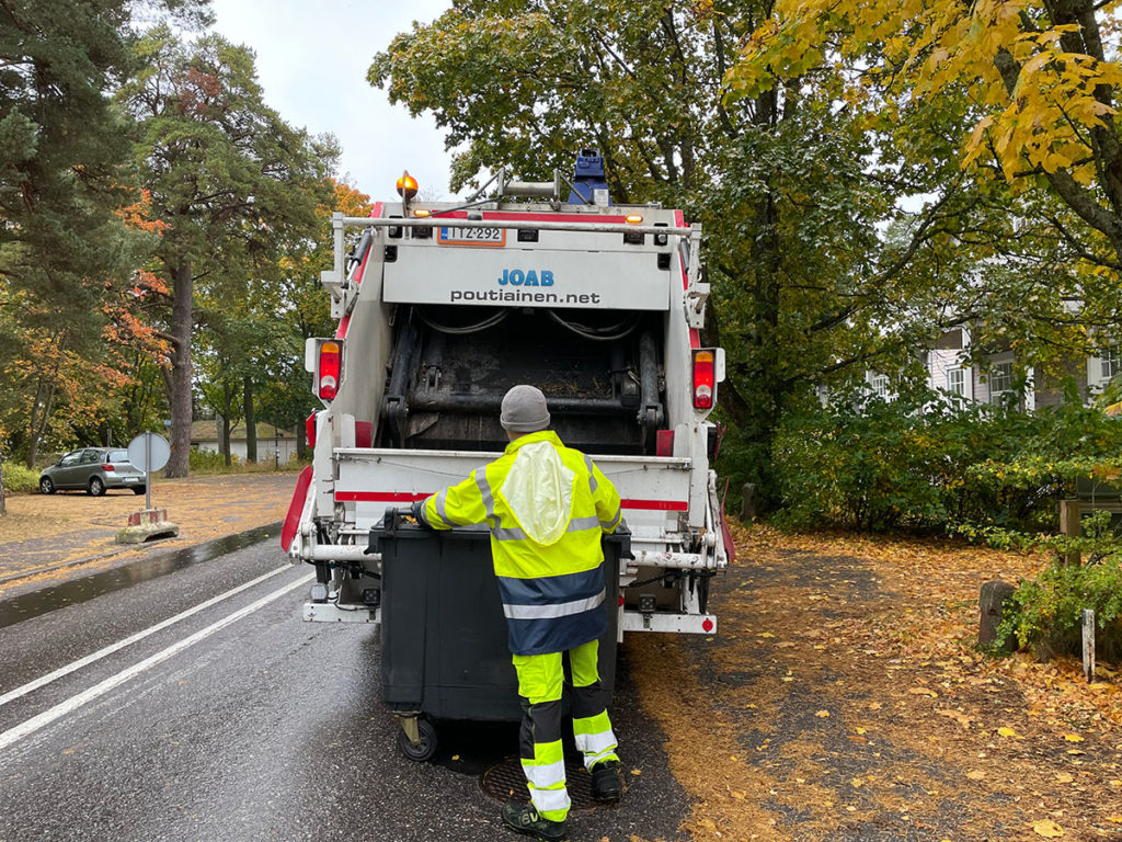 Jäteauton kuljettaja  jäteauton vieressä.