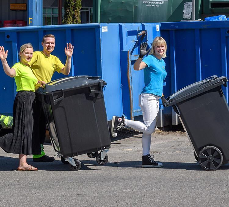 Rosk'n Rollin työntekijöitä jäteasemalla jäteastioiden kanssa.