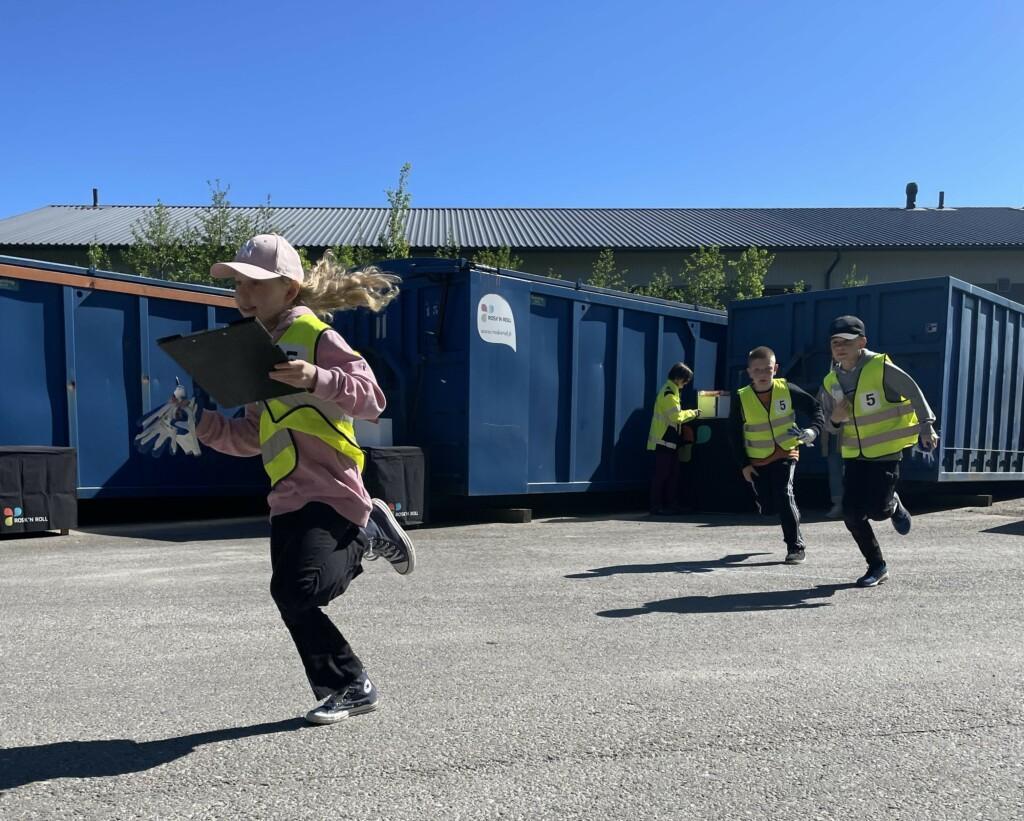 Oppilaat juoksevat jäteasemalla.