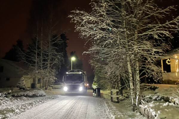 Jäteauton kuljettaja tyhjentää jäteastiaa talvella.