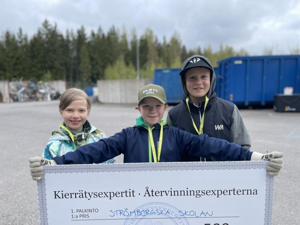 Oppilaat kisaamassa jäteasemalla.