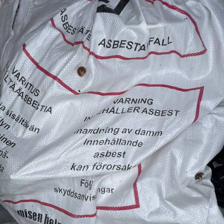 Asbestijätettä pakattu viralliseen, suljettuun pussiin.